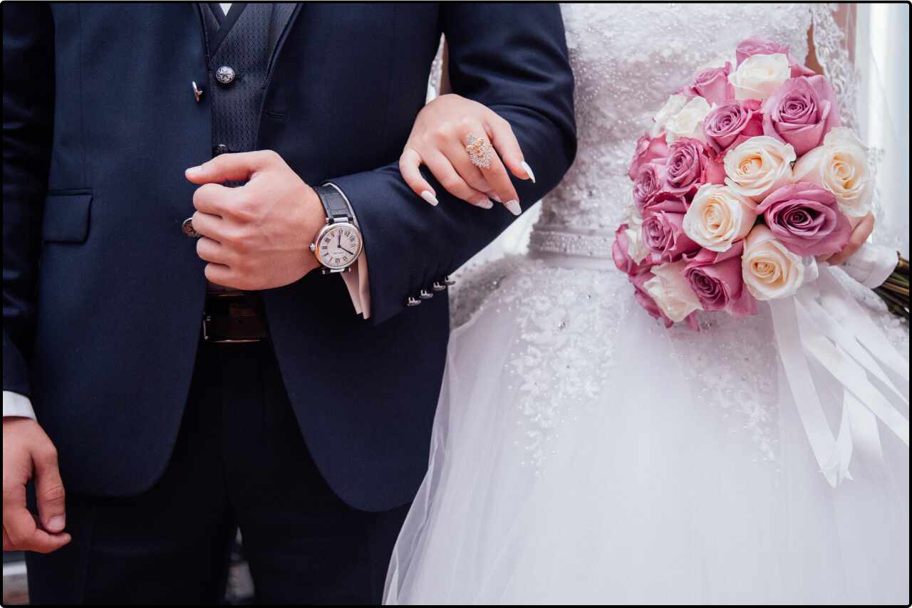 Bride and groom standing walk hand in hand down with flower tora after their wedding ceremony.